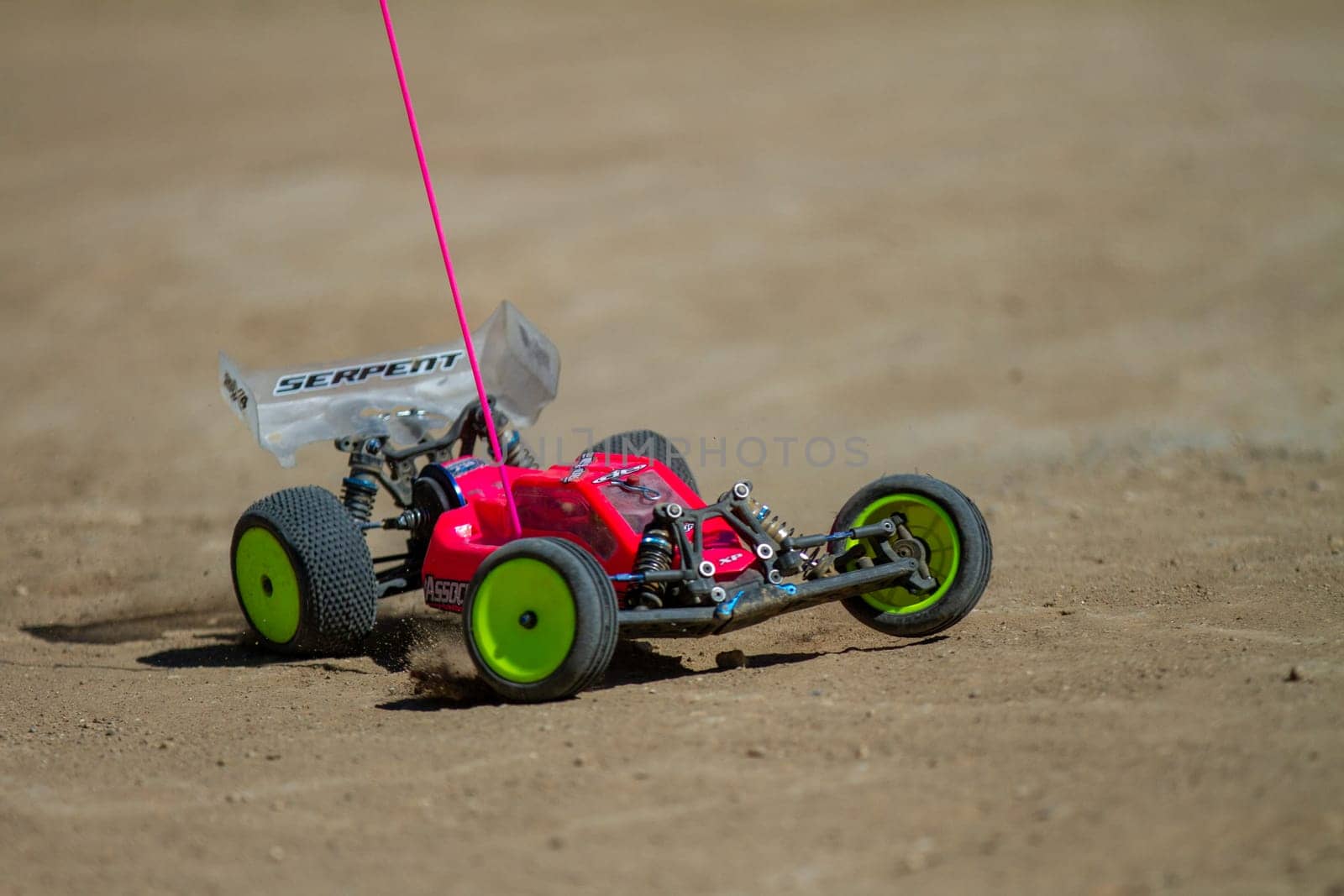 September 11, 2016 - Boise, Idaho: A red and green remote control car is on a dirt road. The car is moving and the camera is following it