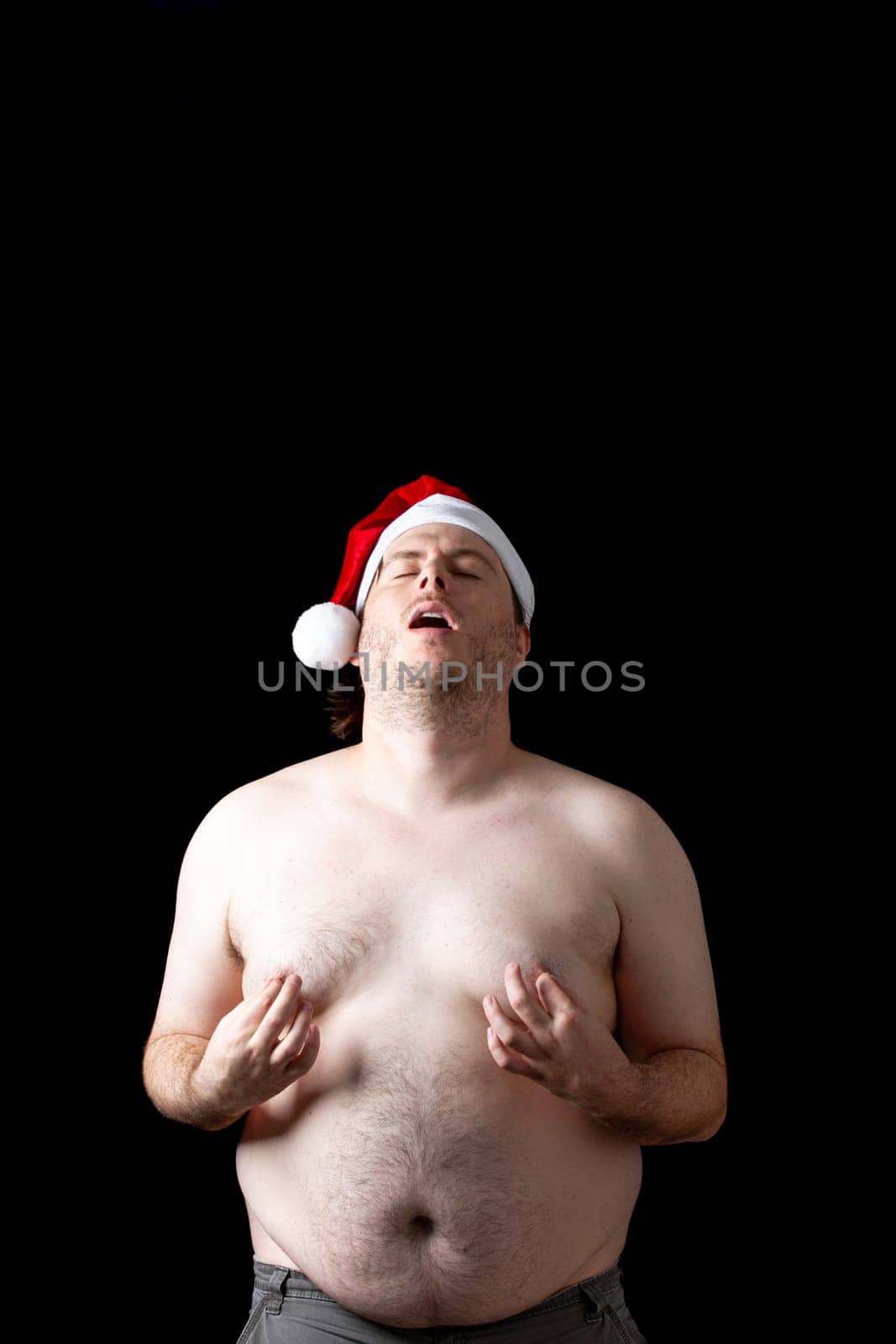 A man with a Santa hat on his head making a funny face