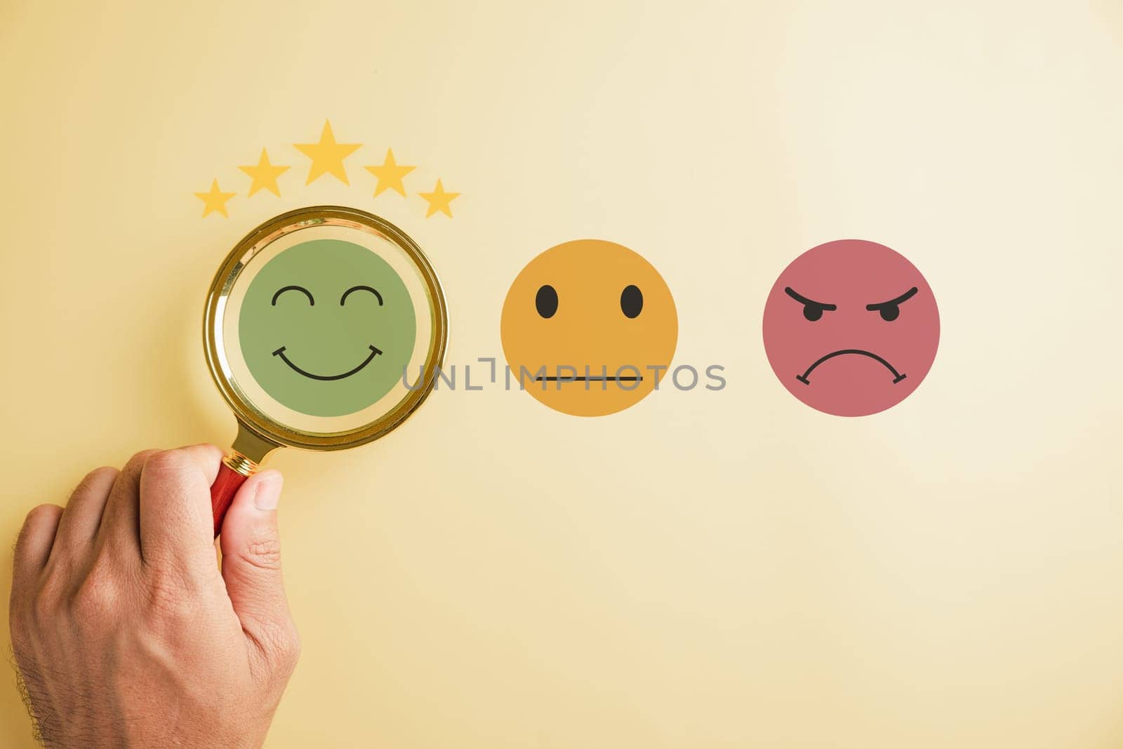 Magnifying glass held by hand selects happy smiley face icon among emotions. Good feedback rating, positive customer review. Experience, satisfaction survey, mental health concept. satisfaction.