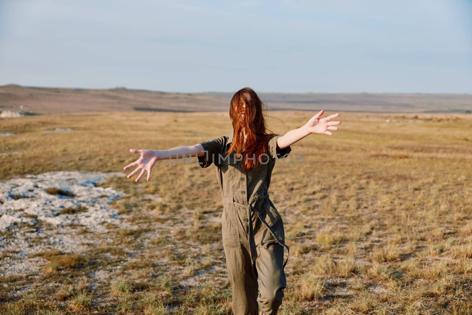 Freedom in the field expressive woman embracing nature and open space with outstretched arms in graceful pose