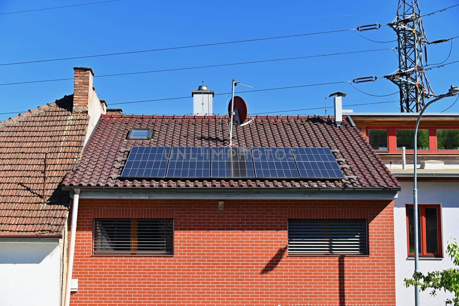 Family house with solar panels on the roof. Home photovoltaic power plant. Concept for industry and green cheaper electricity from renewable sources.