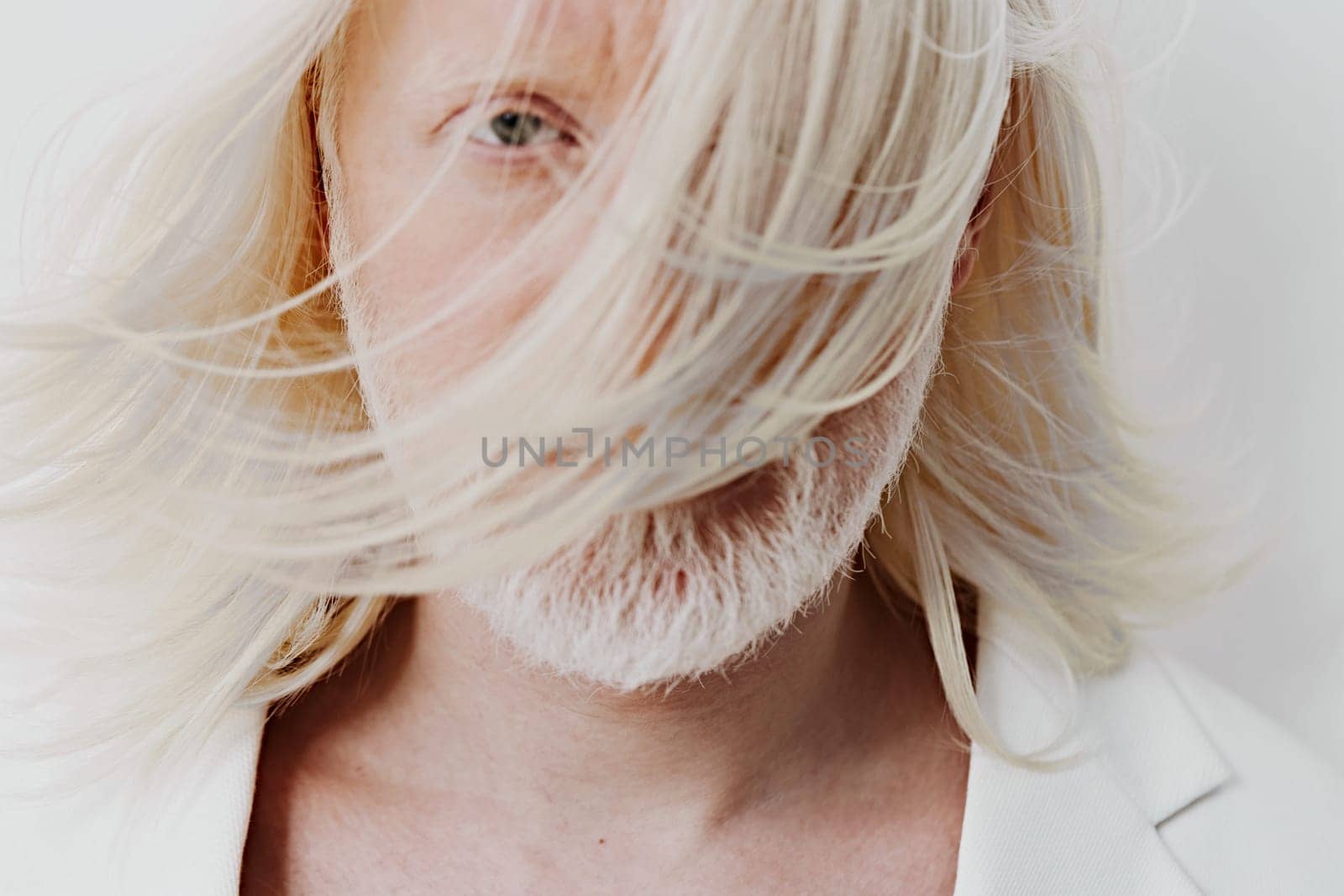 Artistic portrait of a man with long white hair partially covering his face, set against a light, neutral background The image captures a modern and expressive style, emphasizing beauty and uniqueness