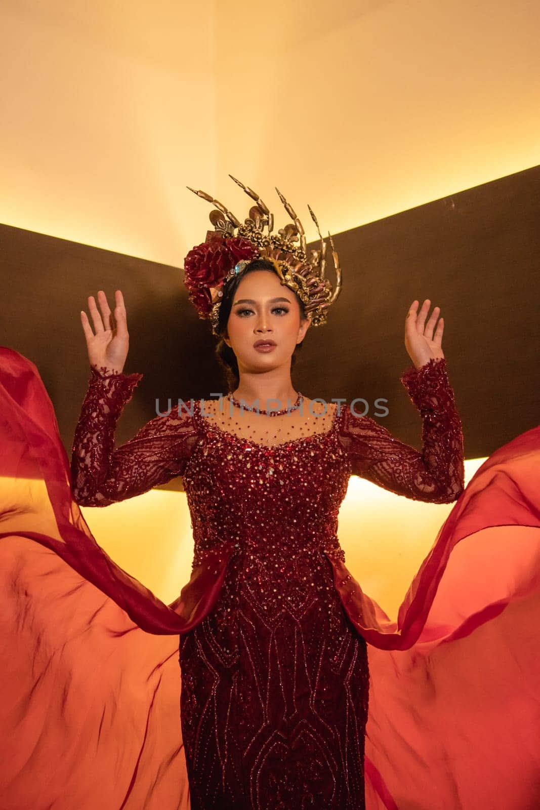 A beautiful Asian woman swings the red fabric tail while wearing a red wedding dress before the wedding ceremony