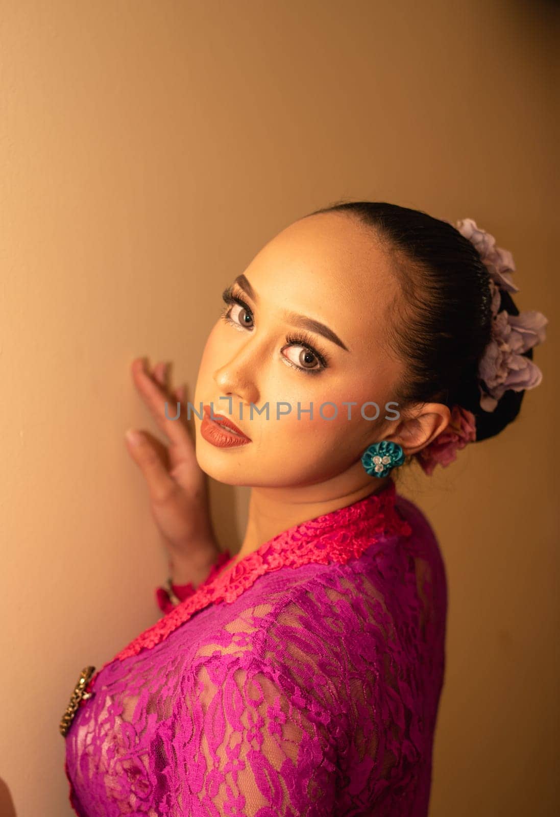 Balinese bride wearing the pink wedding dress before the ceremony has started inside the temple