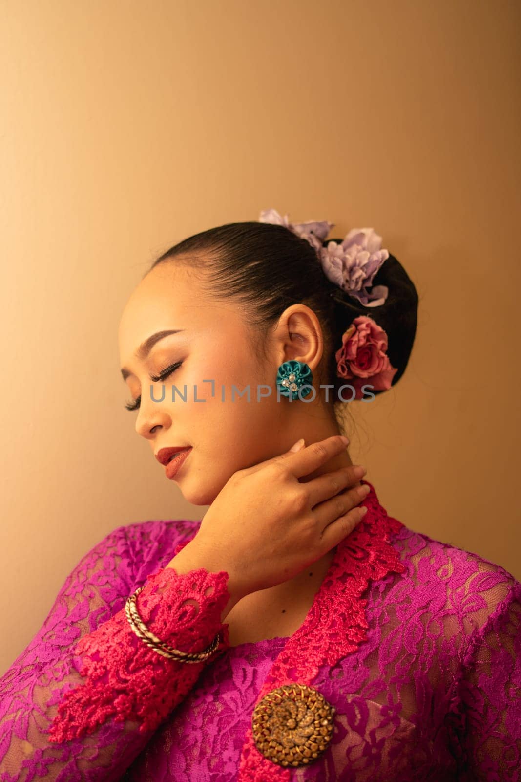 Asian woman touching her neck and feeling sexy with herself while posing inside the cream room