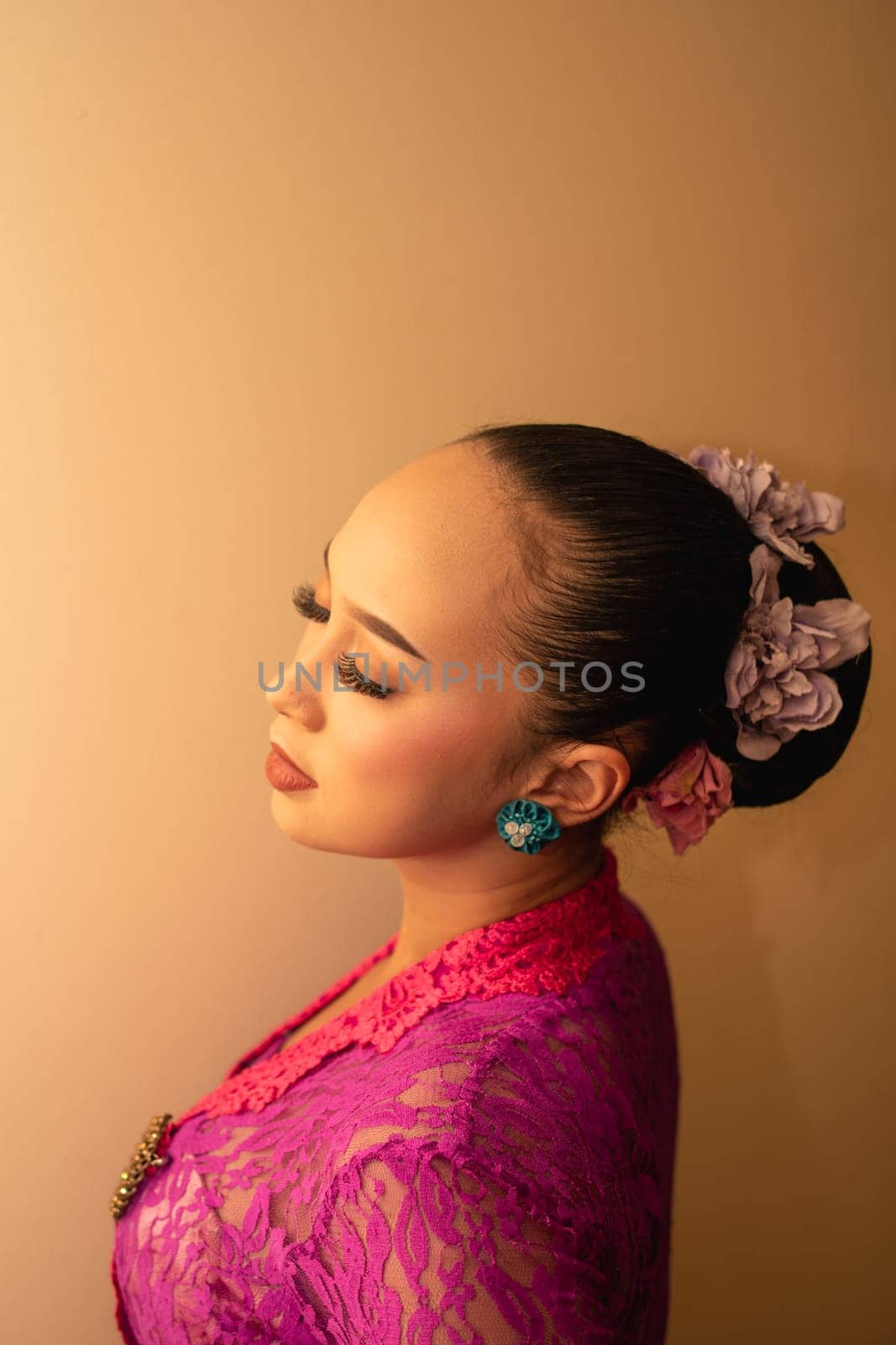 Balinese bride wearing the pink wedding dress before the ceremony has started inside the temple