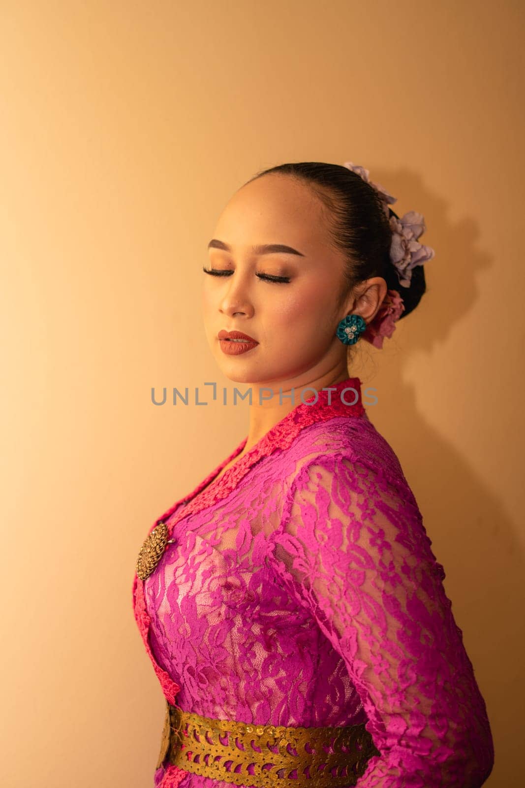 Balinese bride wearing the pink wedding dress before the ceremony has started inside the temple