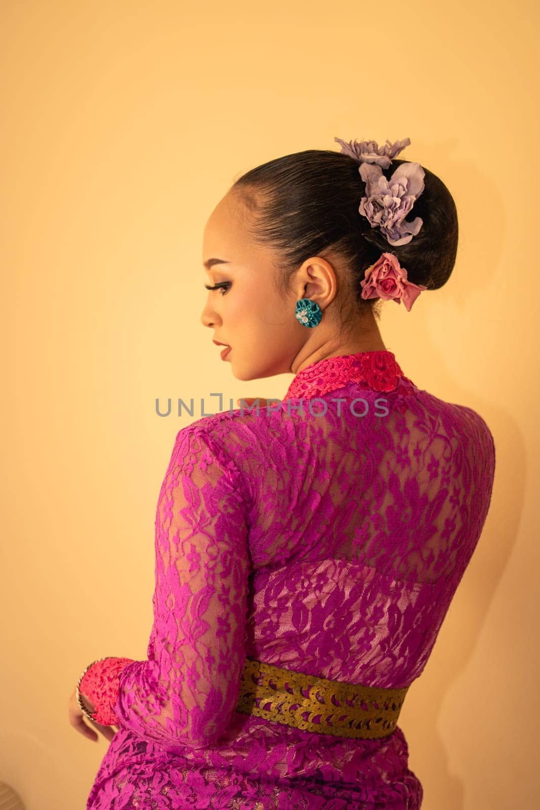 Balinese bride wearing the pink wedding dress before the ceremony has started inside the temple