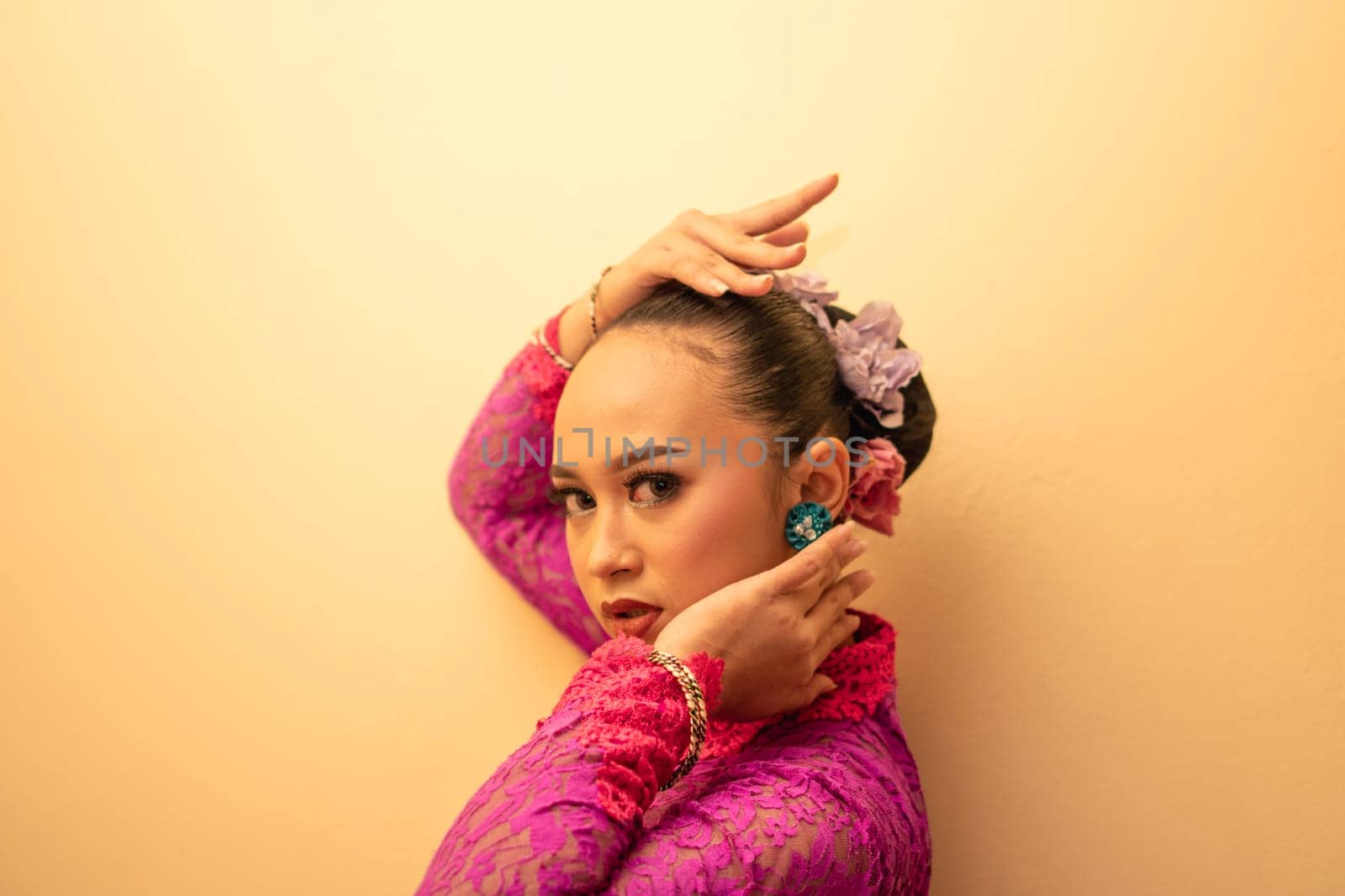 Asian woman touching her neck and feeling sexy with herself while posing inside the cream room