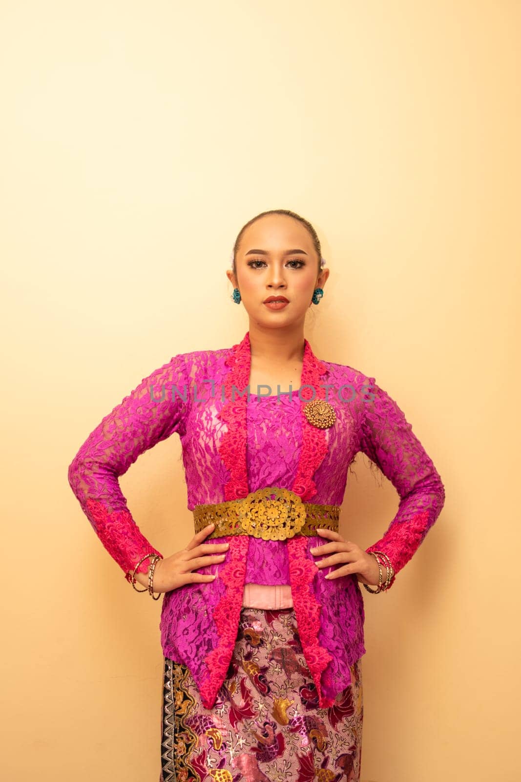 Balinese woman wearing a pink dress called kebaya from Indonesia's traditional dresses inside the temple