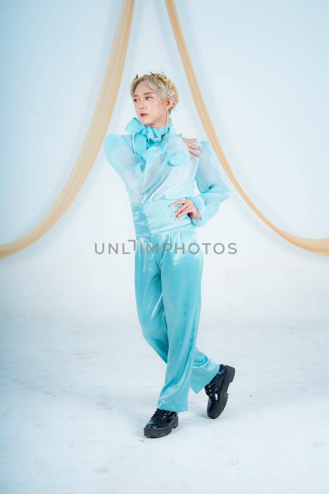 an Asian woman posing elegantly in a blue costume in a white room