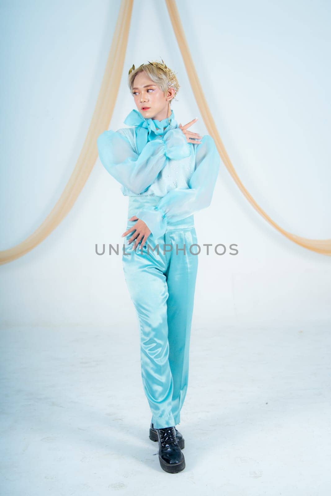 an Asian woman posing elegantly in a blue costume in a white room