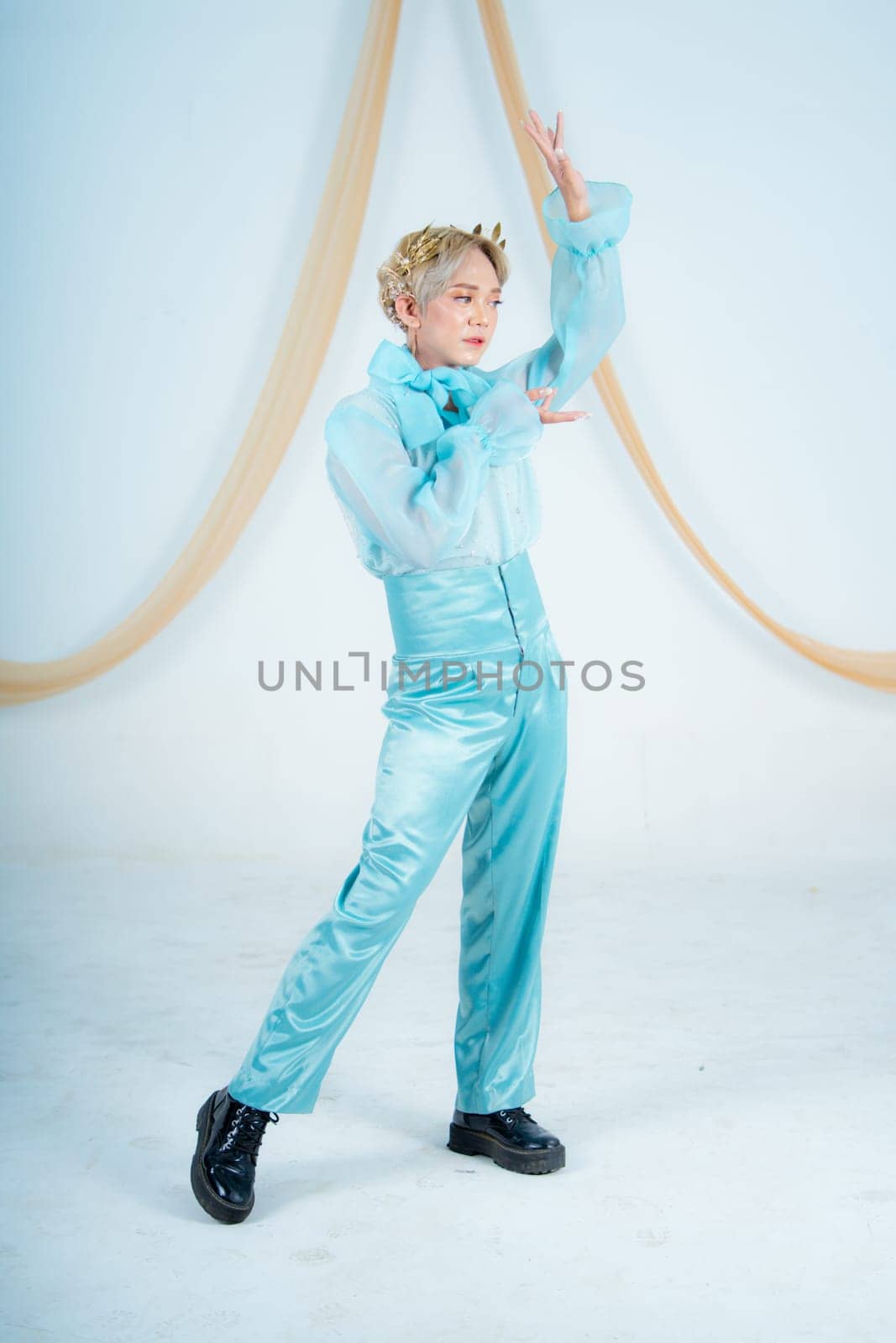 an Asian woman with blonde hair posing with her hands in a white studio