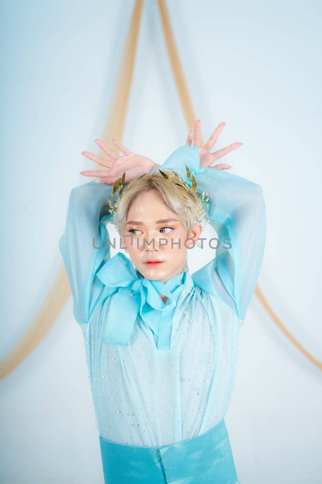 an Asian woman with glowing makeup posing very elegantly in a white room