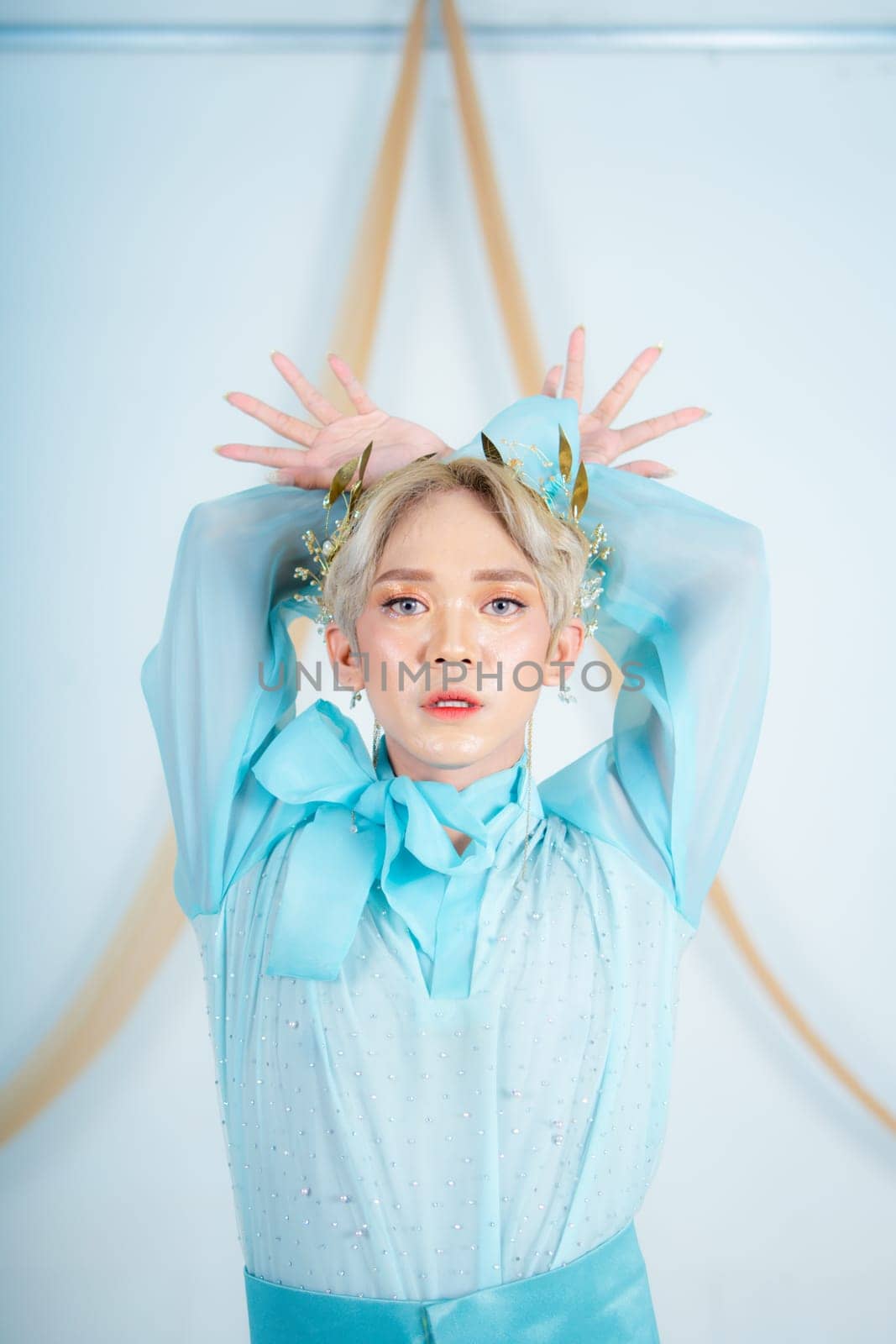 an Asian woman with glowing makeup posing very elegantly in a white room