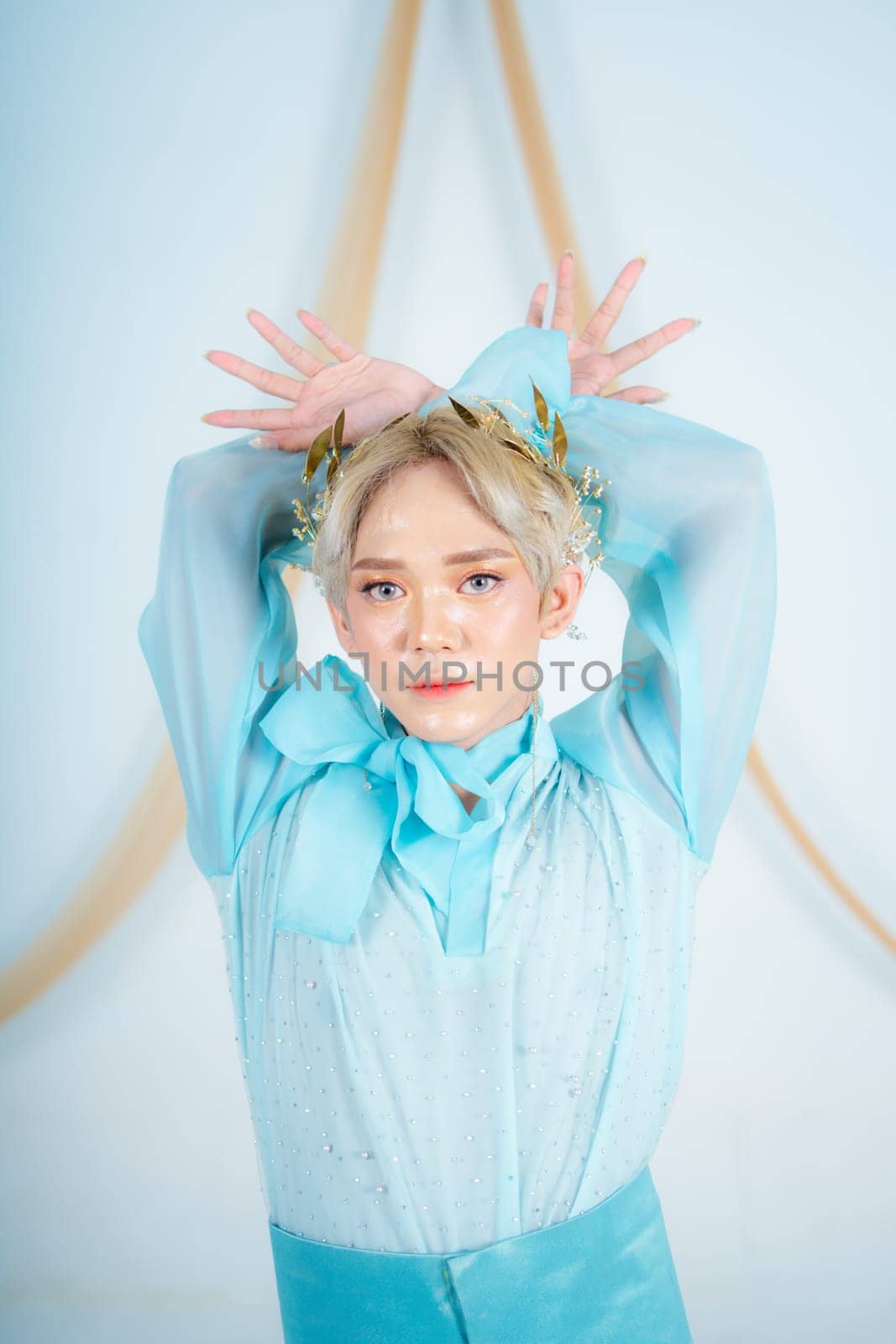 an Asian woman with glowing makeup posing very elegantly in a white room