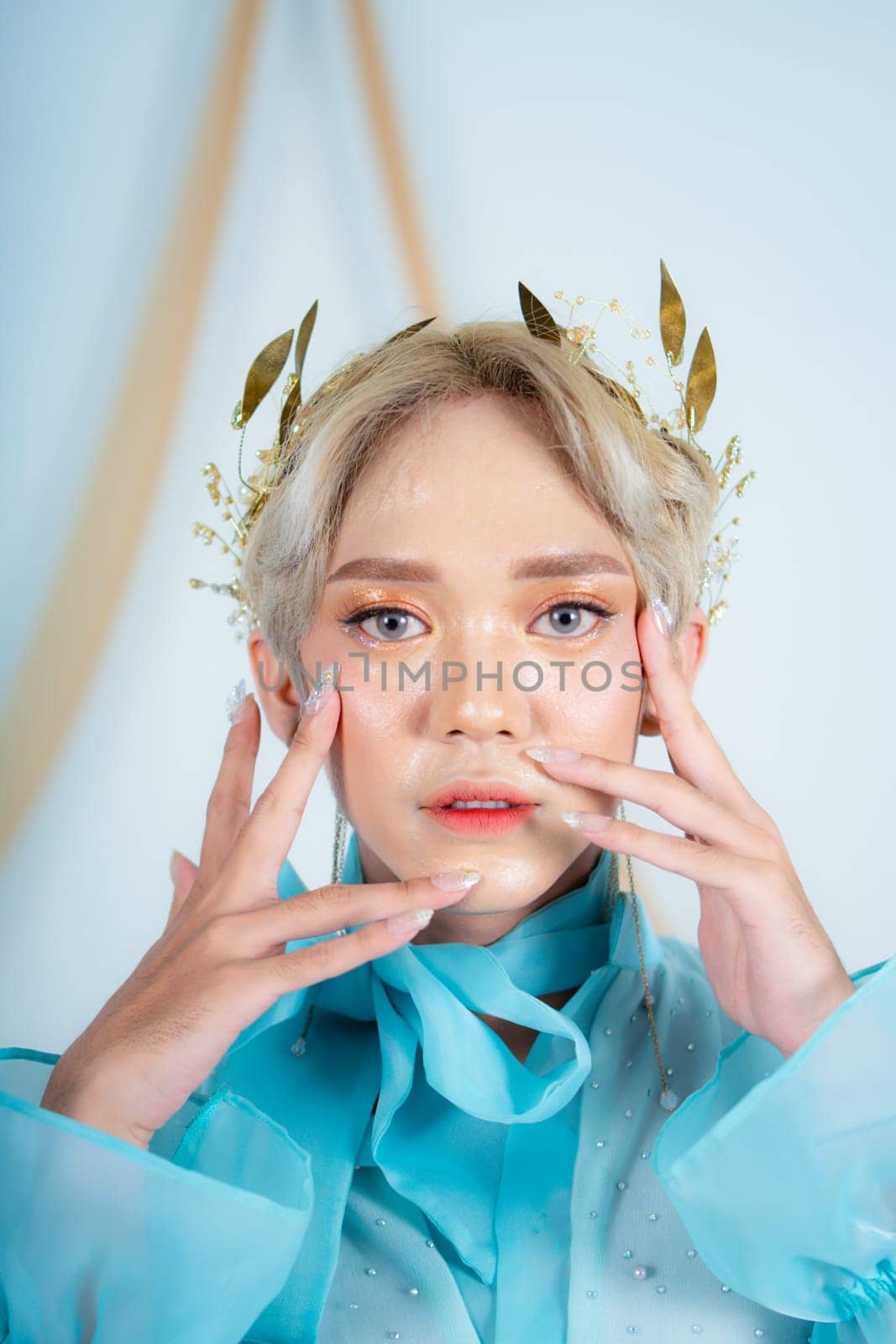 beautiful face of an asian woman with red lipstick and blue eyes in a white studio