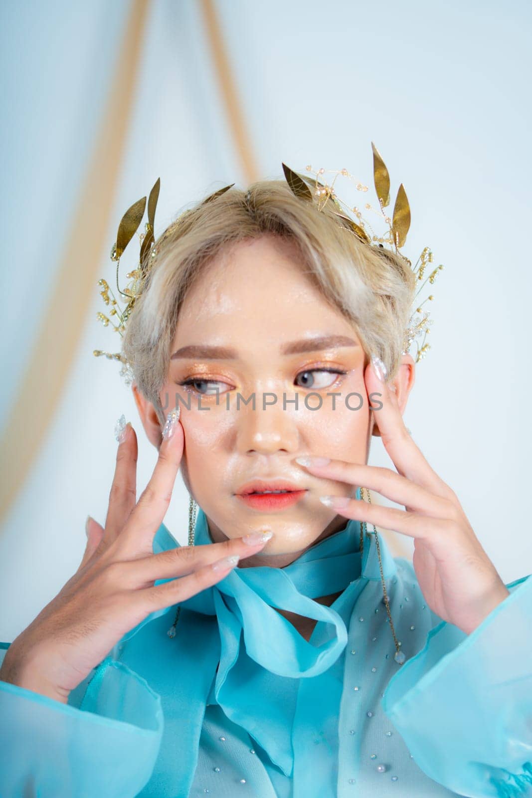 beautiful face of an asian woman with red lipstick and blue eyes in a white studio