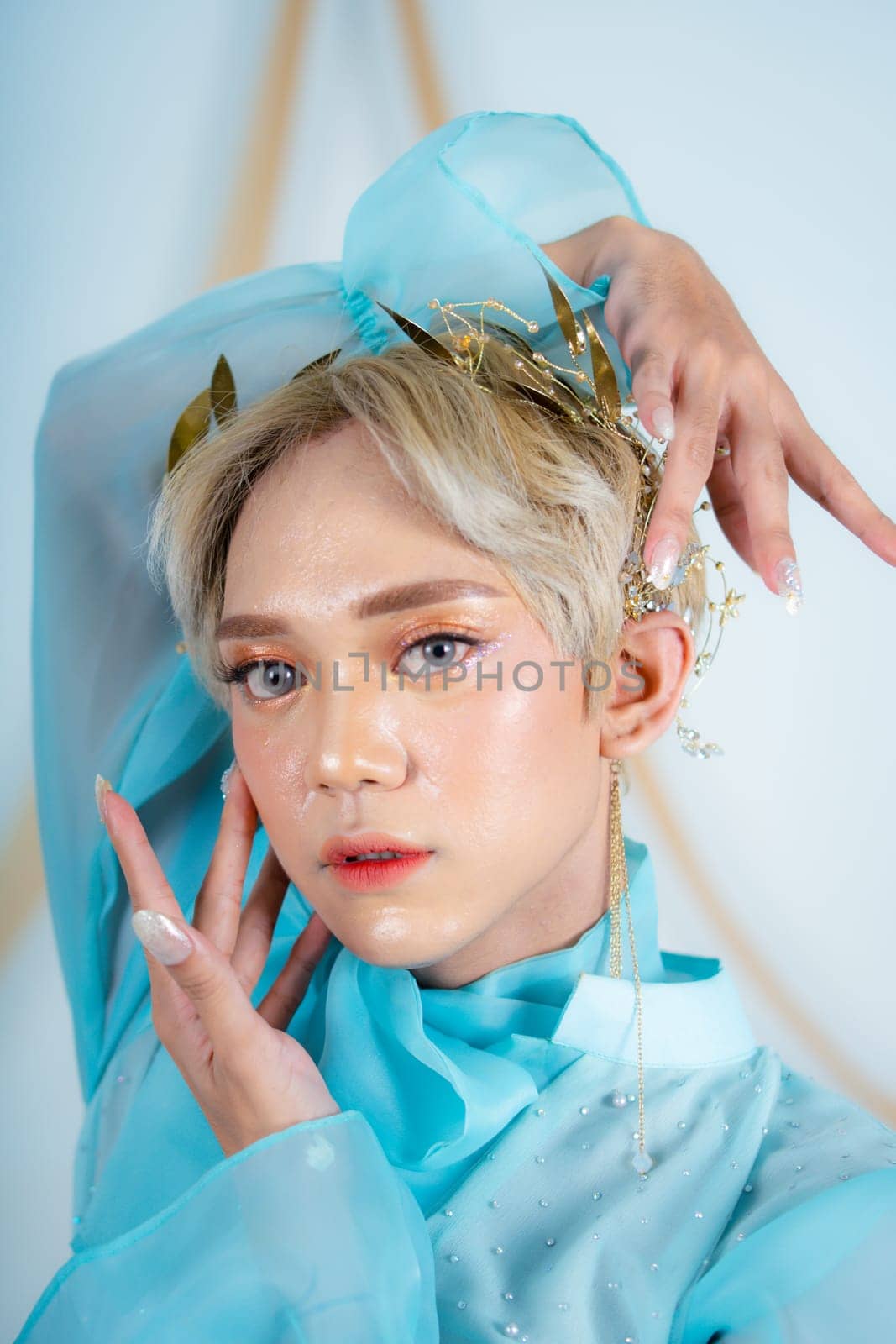 a princess with a blue dress and blonde hair posing very beautifully in front of a white background