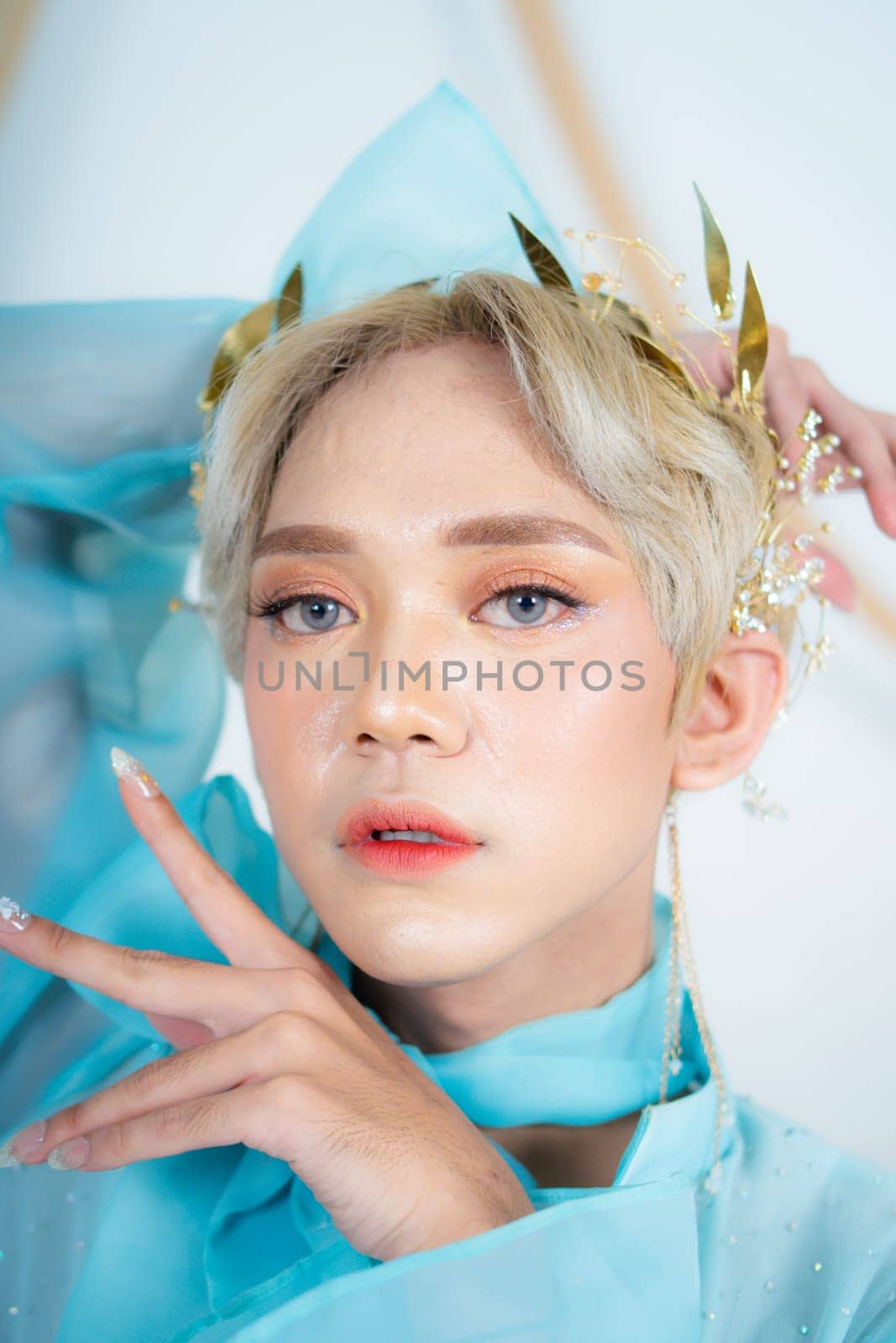 a royal princess in a blue dress posing with her hands very elegantly in a white palace