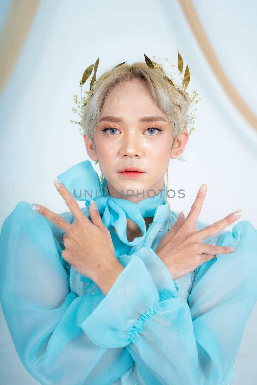 a royal princess in a blue dress posing with her hands very elegantly in a white palace