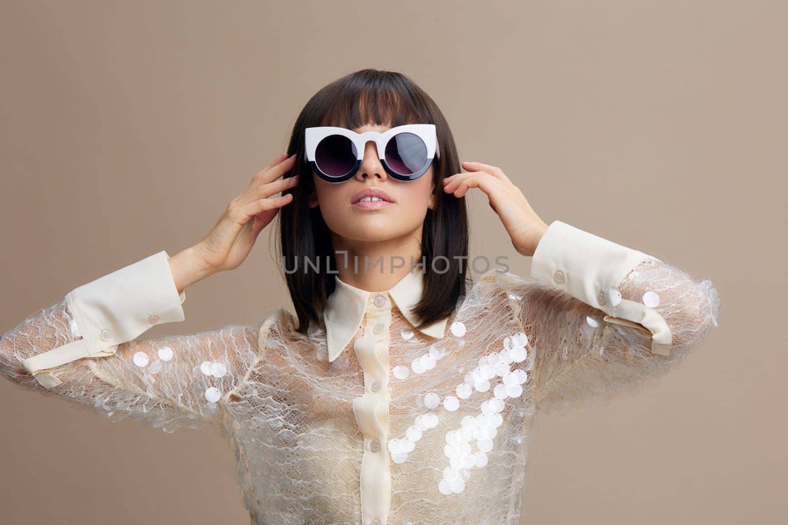 Woman, sequinned shirt, sunglasses a woman in a sequinned shirt and sunglasses smiles at the camera with her hands on her head, exuding confidence and joy