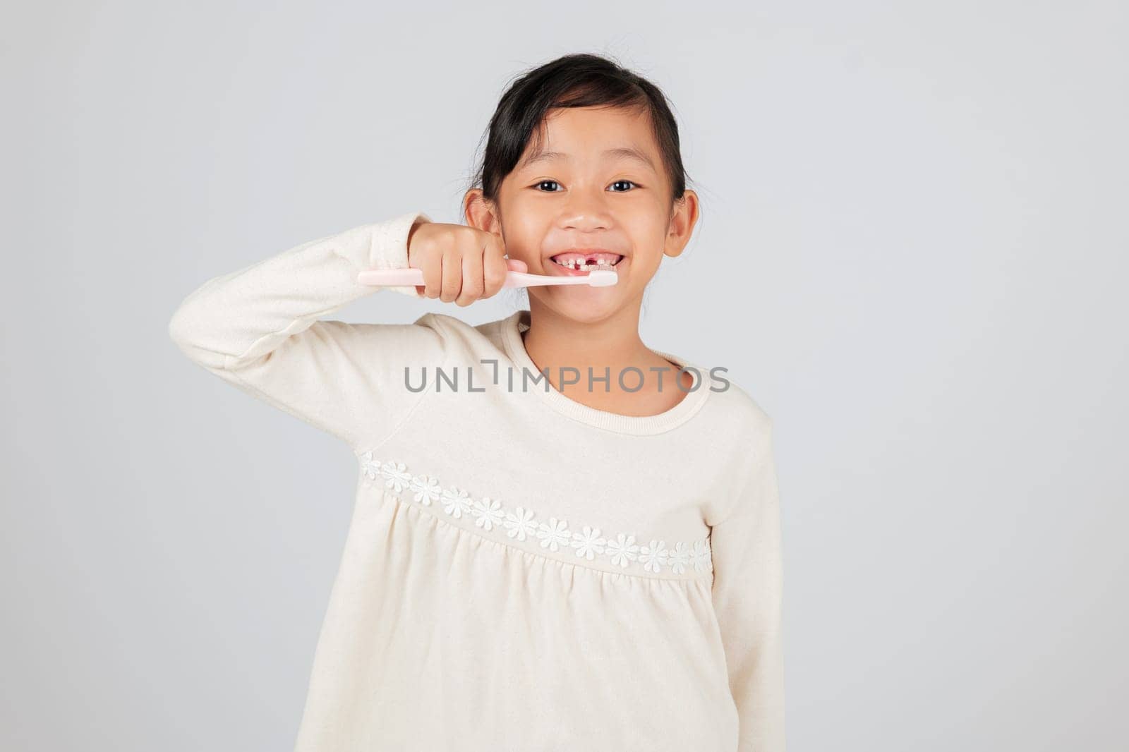 Smiling child with a toothbrush and a tooth gap. The dentist educates on tooth loss and oral care, making daily hygiene an important part of a kid's routine. isolated white background