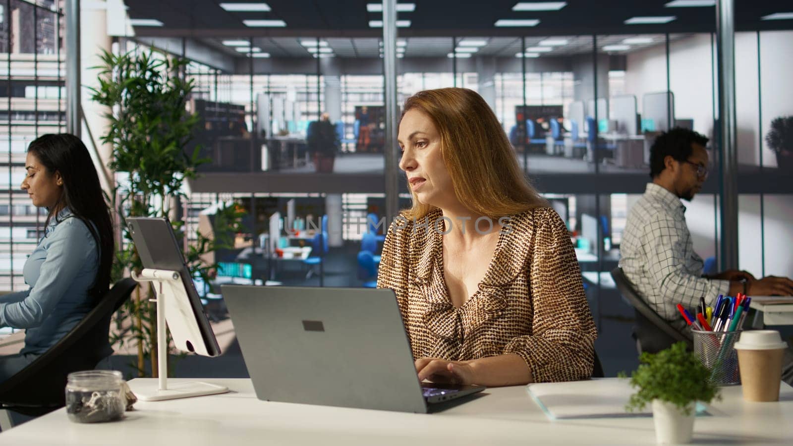 Business manager on a video conference call discusses company goals, focusing on decision making and resource allocation. CEO multitasking operations and task management efficiently. Camera B.