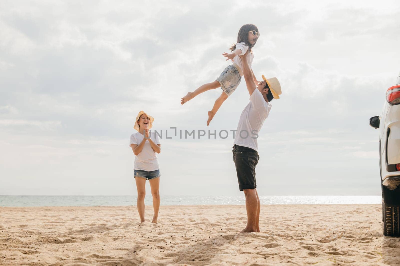 Happy family three playing on sandy beach, Parents father holding child on his shoulders jump their children flying to air, holiday vacations summer road trip, Family day enjoying their time together