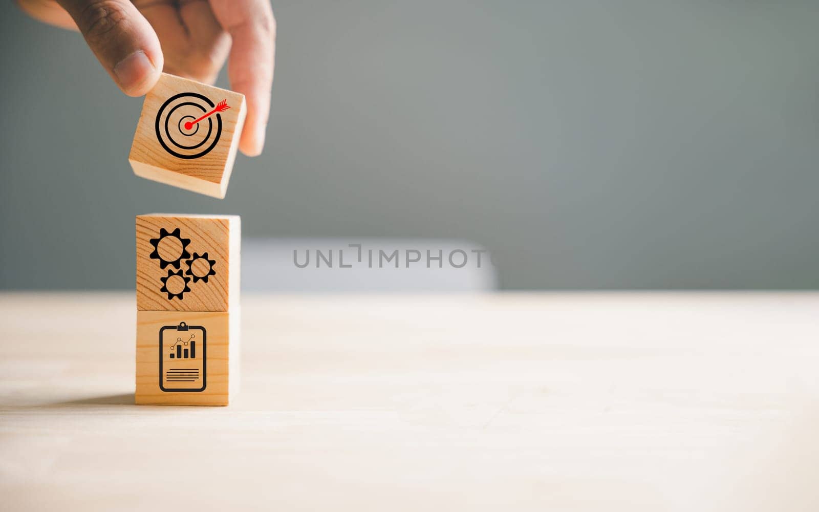 Hand skillfully arranging wood block stacking to depict a business strategy and Action plan, targeting the business concept. This image represents business development and growth.