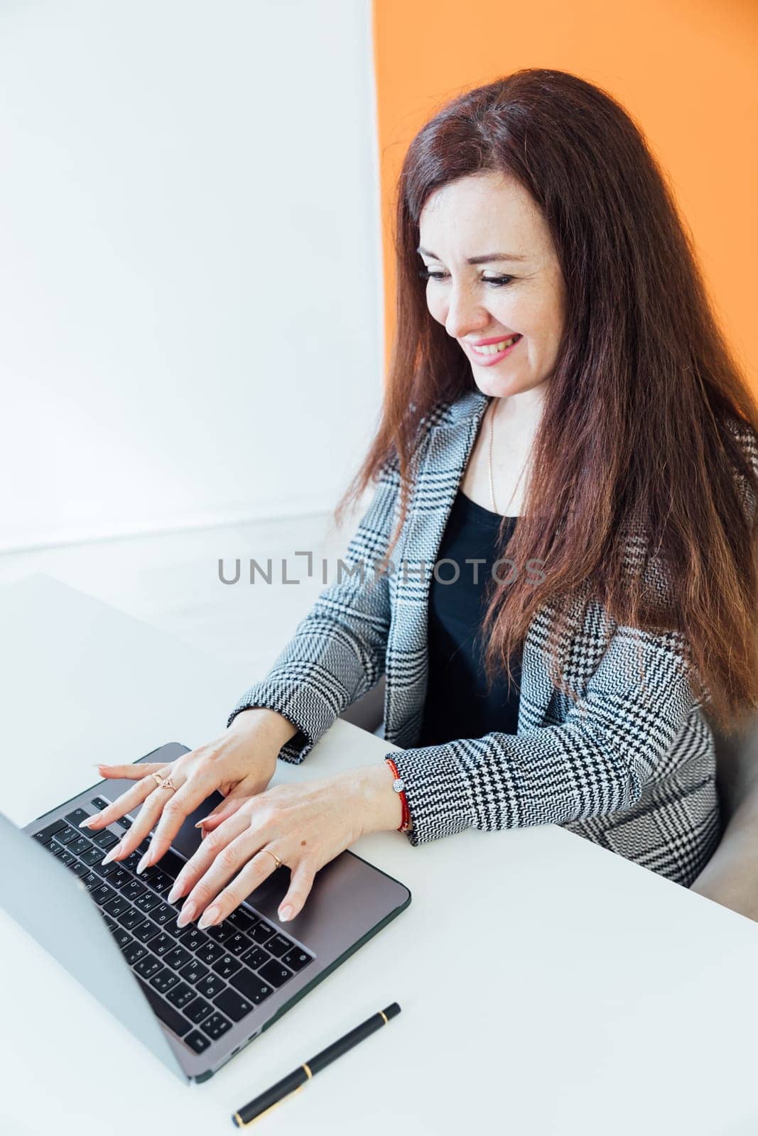 Brunette businesswoman working at desk in office online