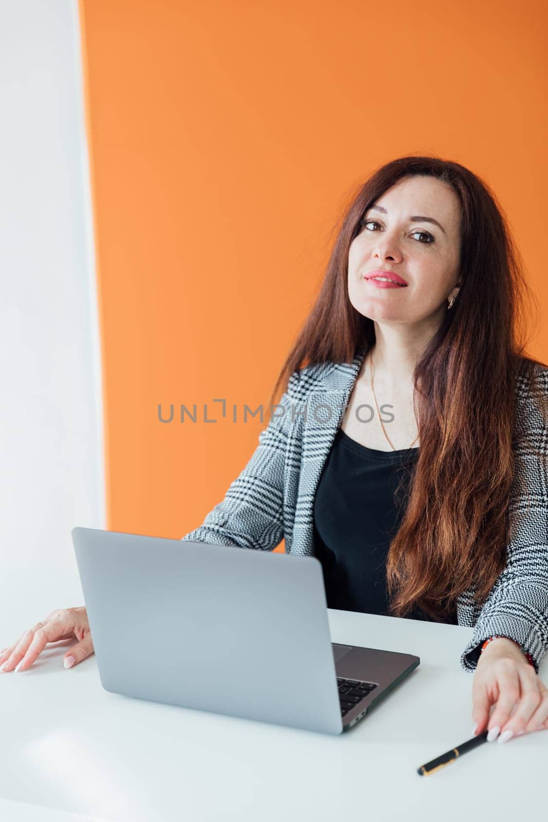 Brunette businesswoman working at desk in office online