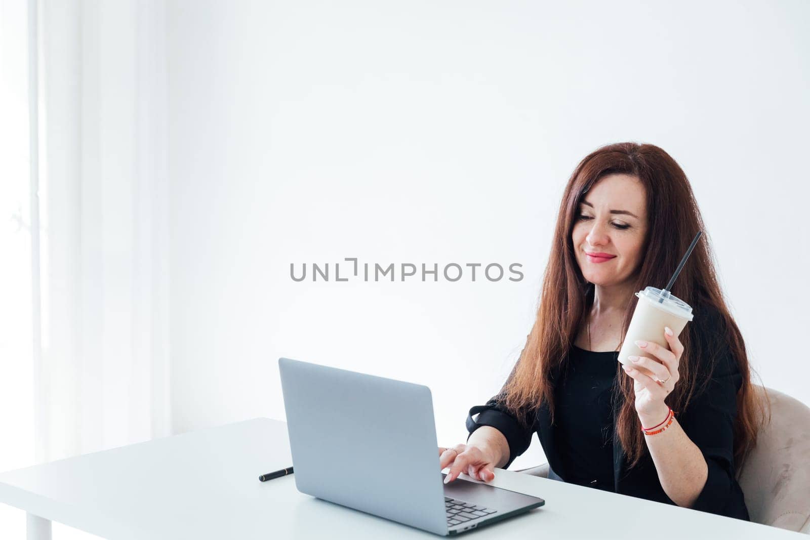Brunette woman working with desk with laptop in white office online