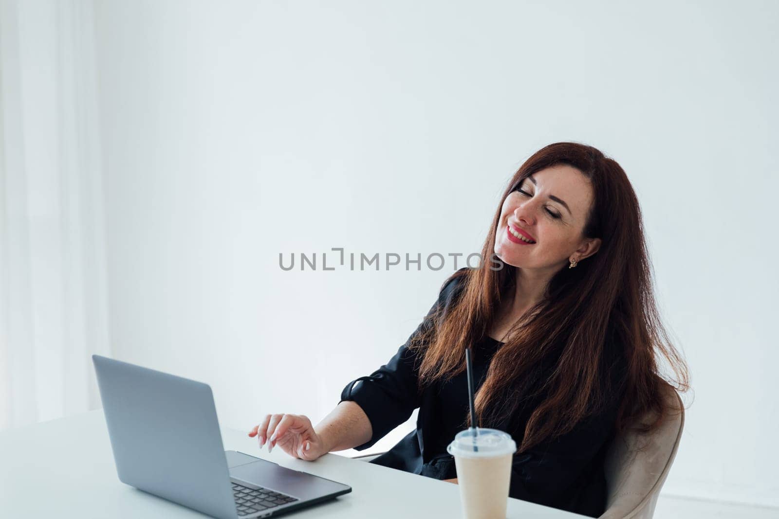 Brunette woman working with desk with laptop in white office online
