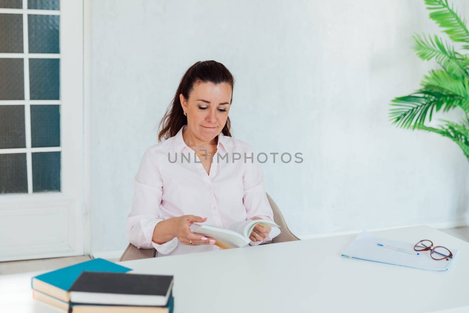 woman working in office at desk with laptop and documents