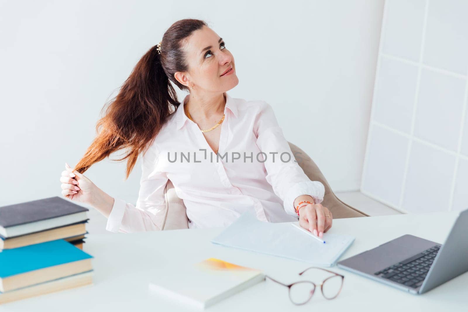 The brunette smiled thoughtfully at the office desk with a laptop