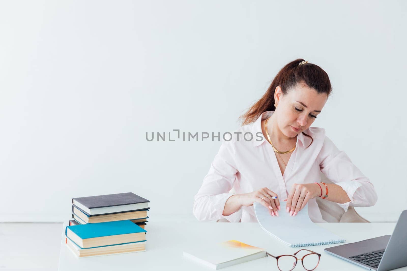 Brunette woman working at office desk with laptop online