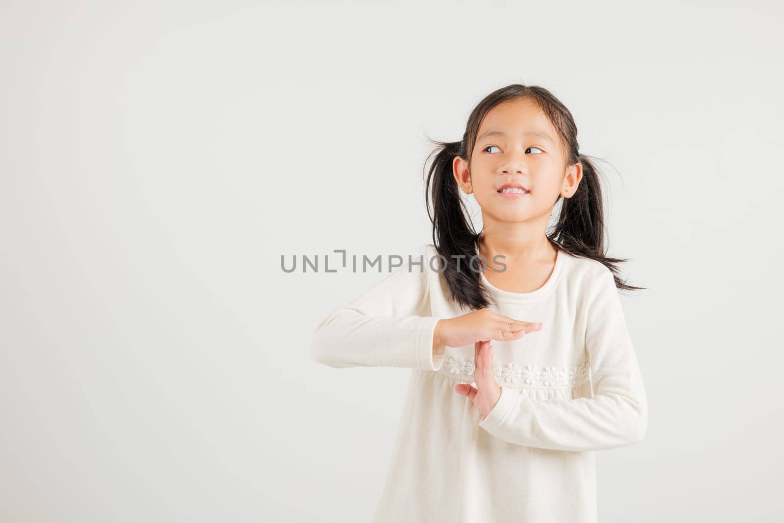 Closeup portrait young kid girl smiling making give time out gesture with hands studio shot isolated on white background, kindergarten child demonstrates break hand sign, stop time with copy space