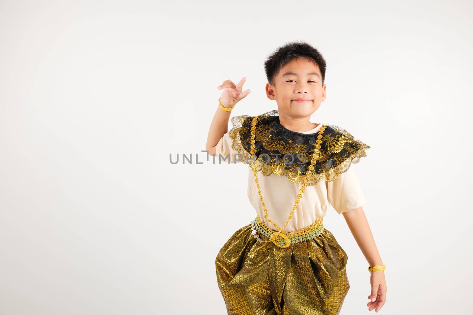 Portrait Thailand kid boy smiling traditional Thai dress costume radiates positivity by forming victory and peace signs, studio shot isolated white background, primary child V sign finger