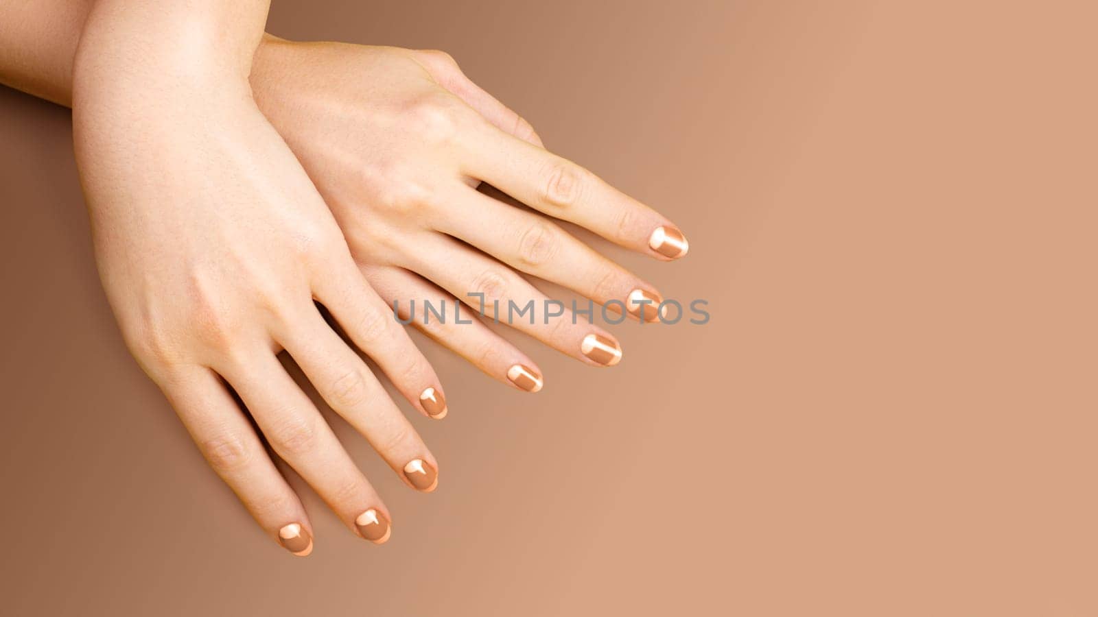 Beautiful Female Hands with bright Orange Manicure like Candy Corn on Yellow Background. Manicured Nails with Creative Gel Polish Design. Halloween Style