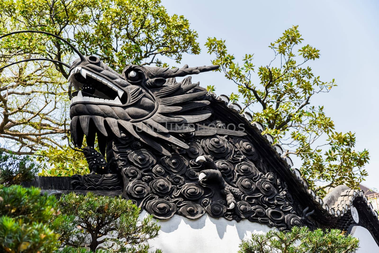 Shanghai, China - 1 April 2025: Dragon carving on the tiled roof of yuyuan garden, symbol of Chinese culture, harmony and classic garden design