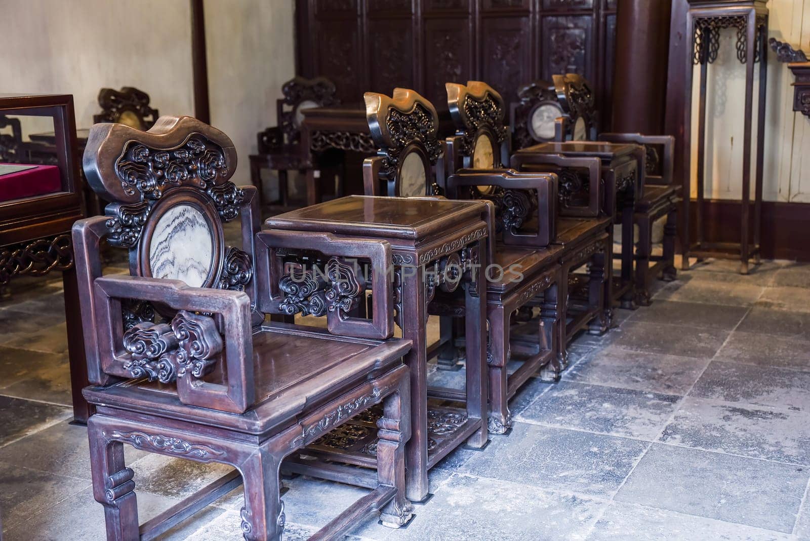Shanghai, China - 1 April 2025: Artistic banyan root chairs inside He Xu Hall, part of the historic Dianchun Hall in Yuyuan Garden, famous for unique woodwork