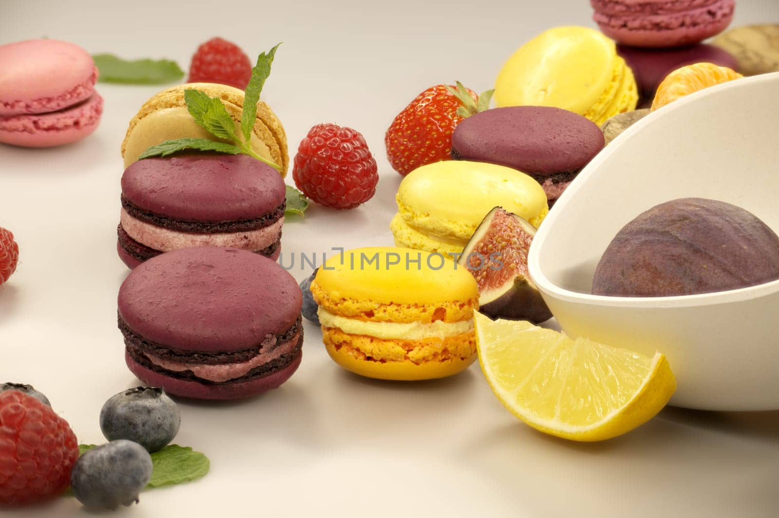 Vibrant scene of a table filled with an array of macaroons and fruits suggests a setting for delightful and healthy snack, emphasizing natural foods and the vibrant colors of fresh produce