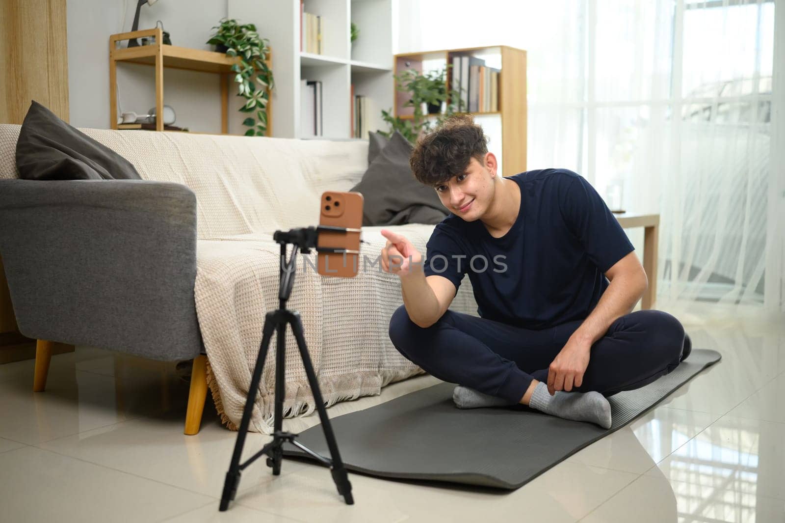 Content creator recording workout session on smartphone at home. in living room.