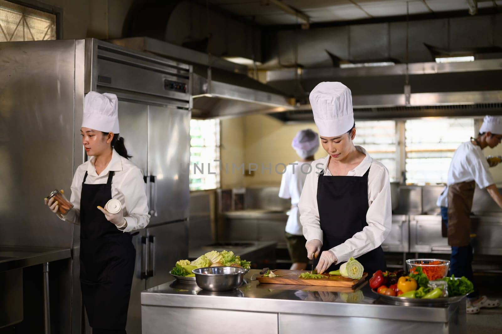 Culinary student practices chopping vegetables during a hands on cooking class in a kitchen.
