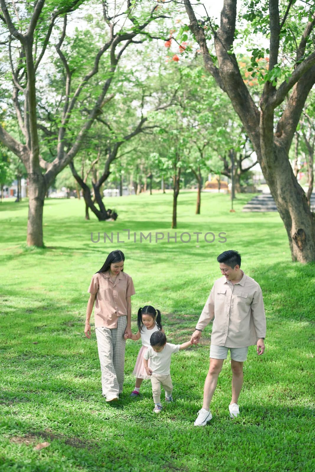 Parents enjoying a peaceful stroll with their children surrounded by vibrant nature.