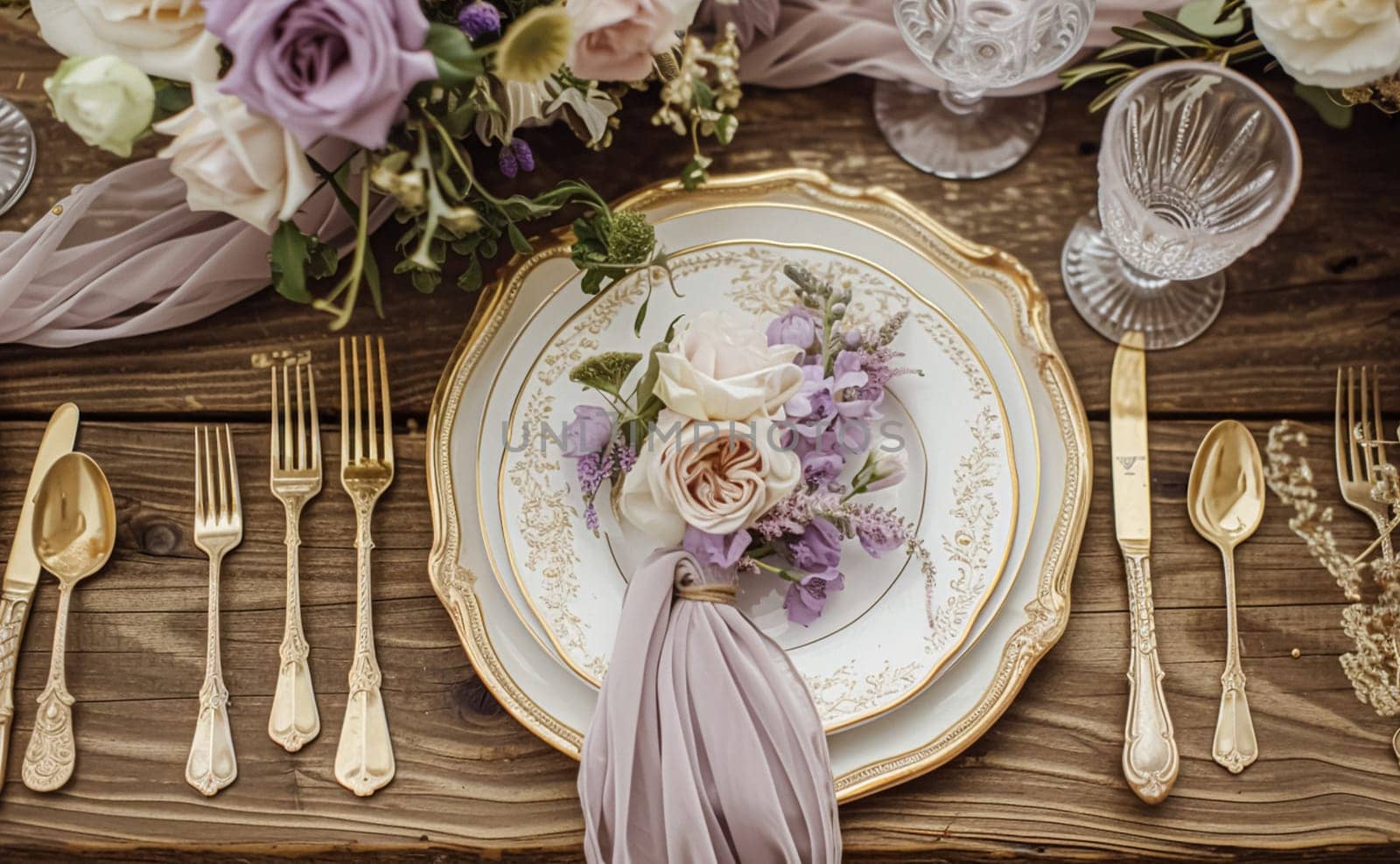 Elegant wedding table with floral centerpiece, gold accents and purple lavender details