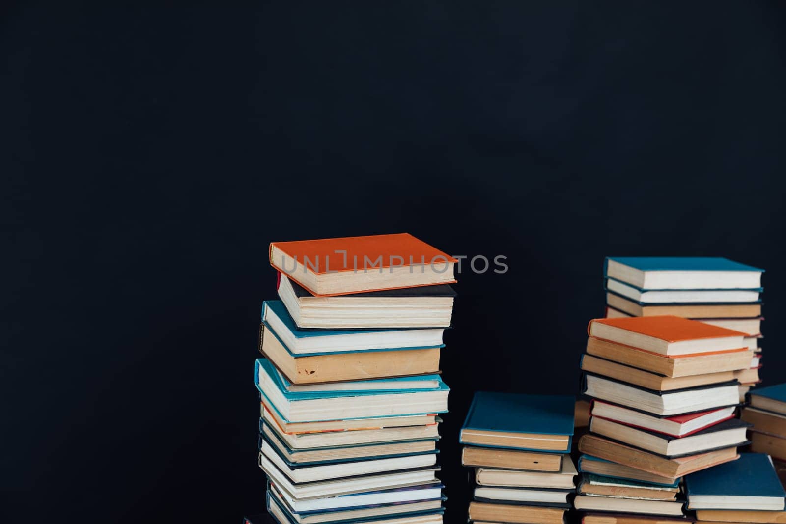 Stacks of old educational books for learning on a black background