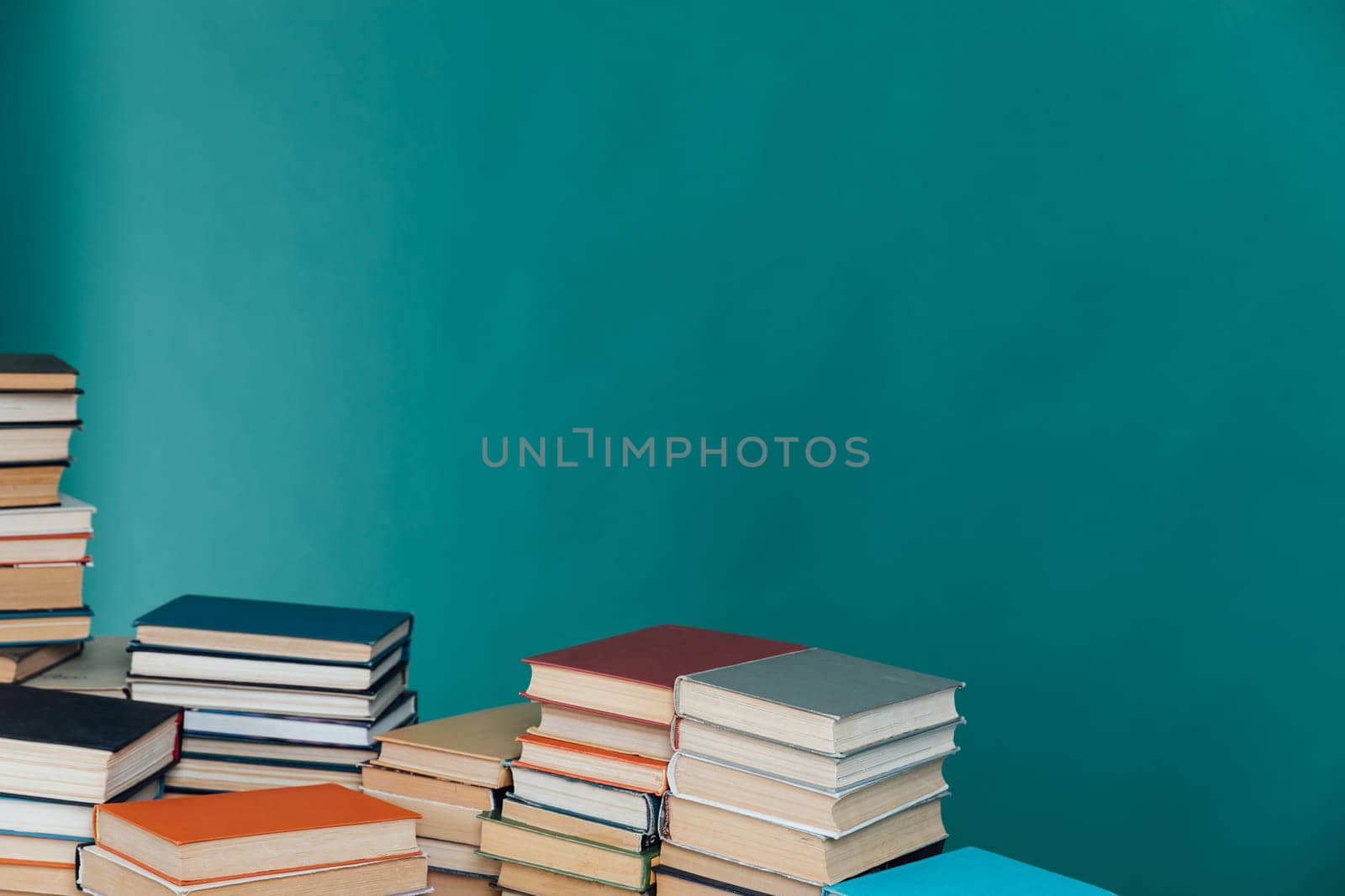 Stacks of old educational books for learning on a green background
