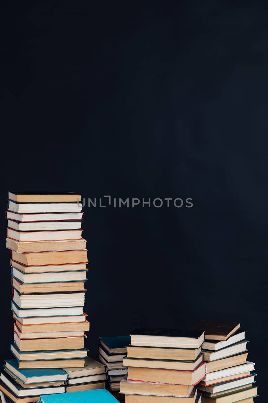 Stacks of old educational books for learning on a black background